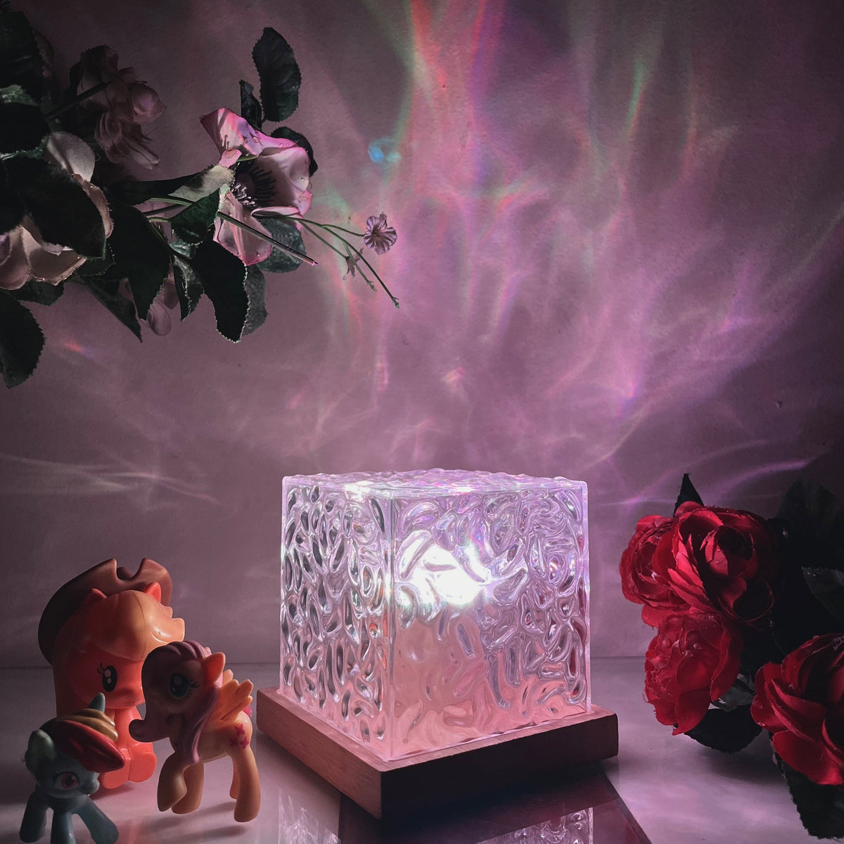 Aurora-Lampe in Würfelform mit strukturierter transparenter Lichtfläche und dunkler Basis in Holzoptik