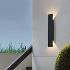 Schwarze vertikale LED-Außenwandleuchte mit warmweißem Licht an einer Fassade