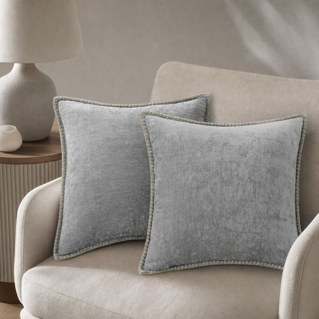 Quadratisches Zierkissen mit weicher Oberfläche und dekorativer Kantenborte auf einem Sofa