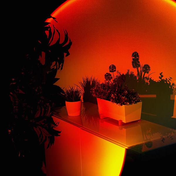 Schwarze LED-Sunset-Lampe mit rundem warmem Lichteffekt auf einem Tisch